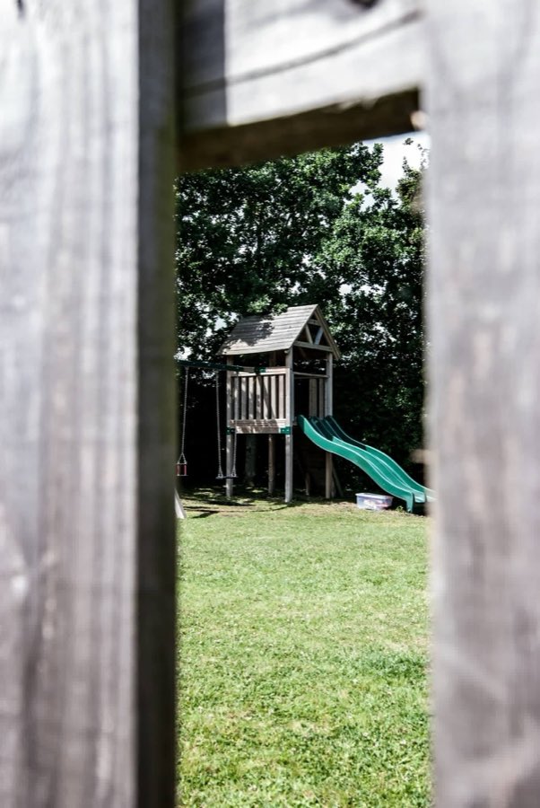 The children's play area in the garden, seen through the fence